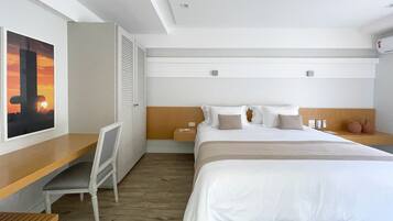 Una habitación de hotel con cama, mesitas de noche, escritorio y silla.