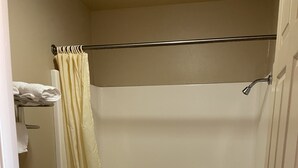 A small bathroom with a toilet, a bathtub, and a shower curtain.