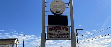 A sign for All Star Inn, Grill Dugout Bar, and Rocky's Tails & Shells.