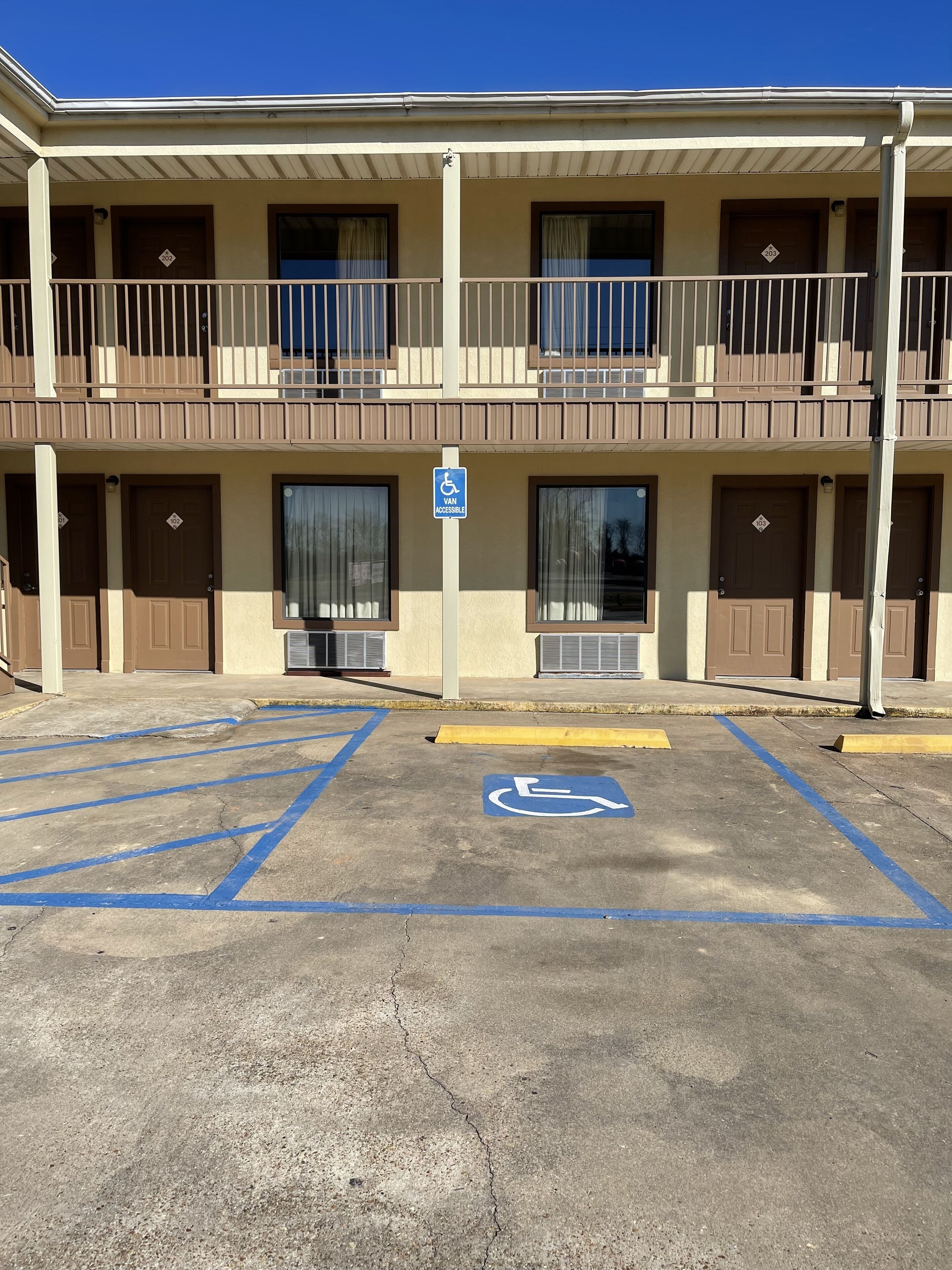 Un hôtel à plusieurs étages doté d’un parking, dont une partie est réservée aux personnes handicapées, et qui comprend une place de stationnement adaptée aux personnes à mobilité réduite.