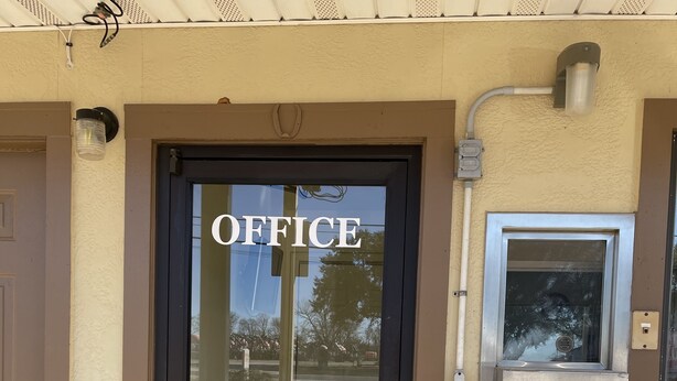 An office entrance with a glass door, a metal handle, and a small window above the door.