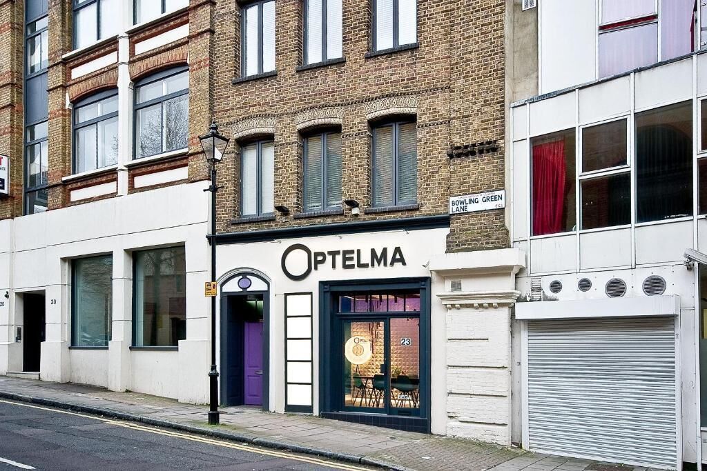 Ein Gebäude mit einer Schaufensterfront, das 'Optelma' in der Bowling Green Lane trägt.