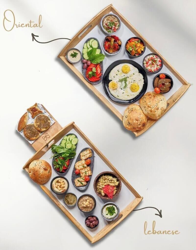 A variety of food items arranged on wooden trays, including bread, vegetables, and dips.