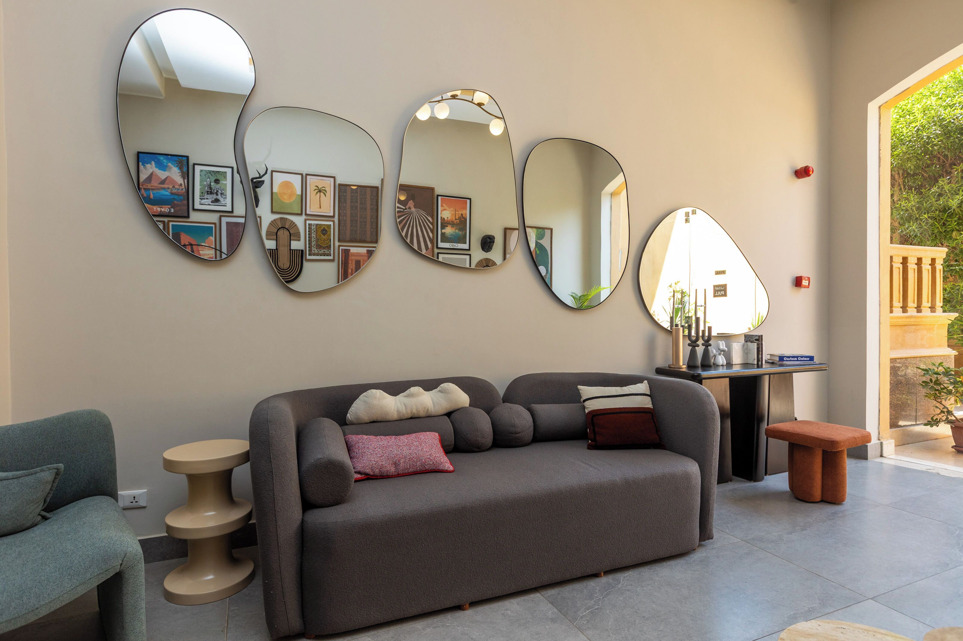 Ein modernes Wohnzimmer mit einem grauen Sofa, einem kleinen runden Tisch und einer Bank.