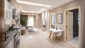 A modern kitchen with a dining area, a TV, and a door leading to another room. - Prime Residence New Cairo (New Cairo)