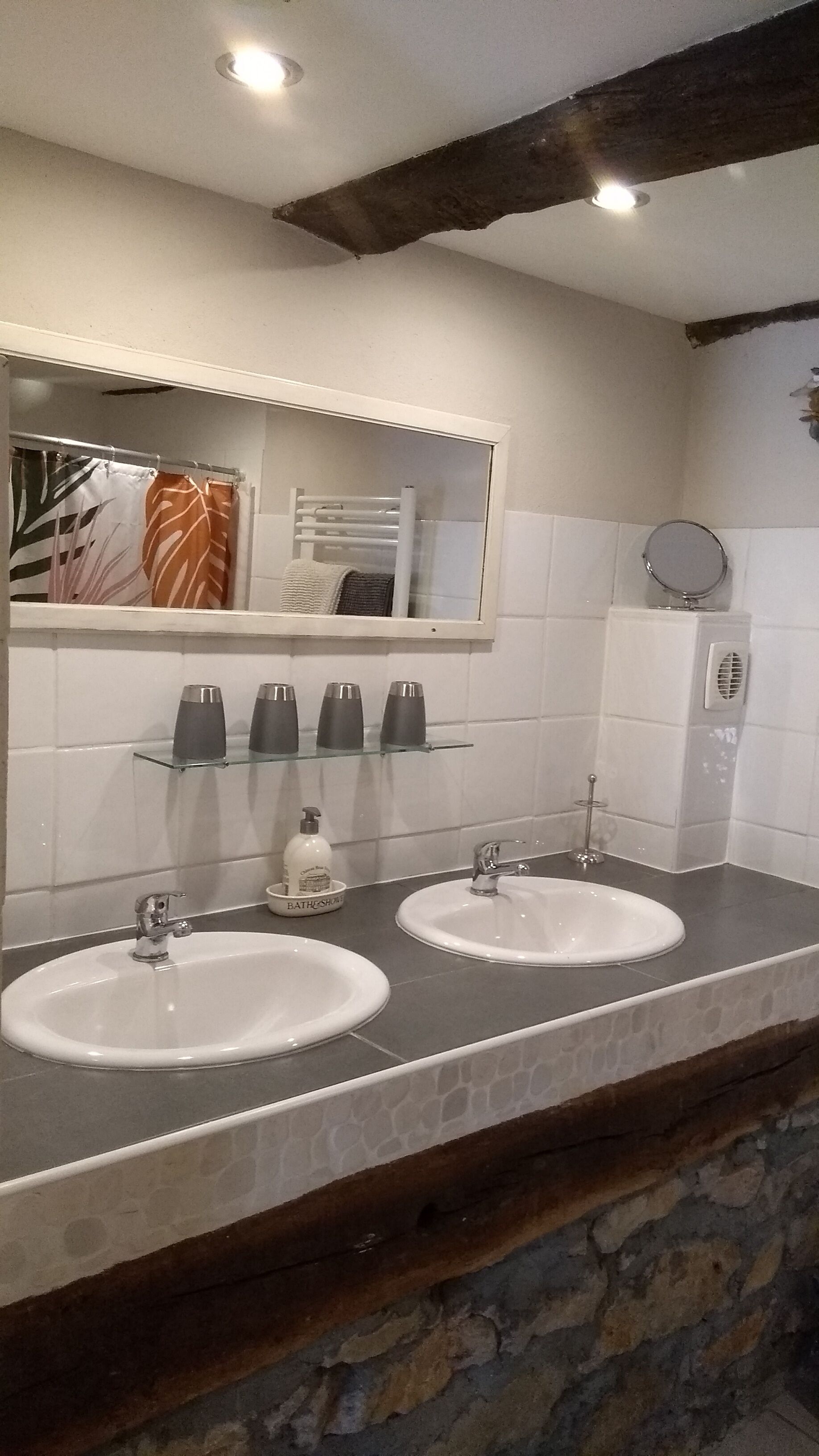 Ein Badezimmer mit zwei Waschbecken, einem Spiegel und einem Handtuchhalter.