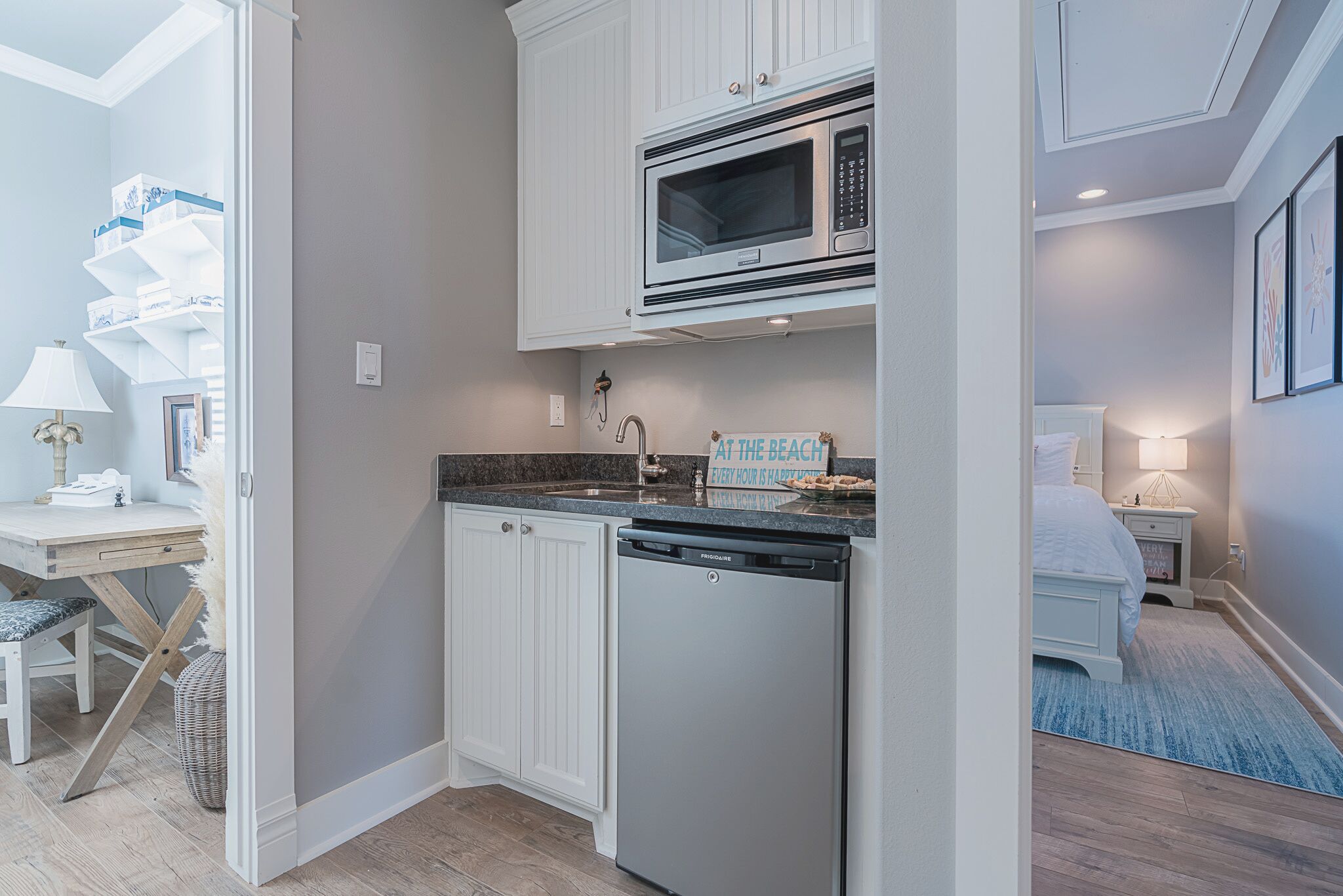 A compact kitchen with white cabinetry, a built-in microwave, and a dishwasher.