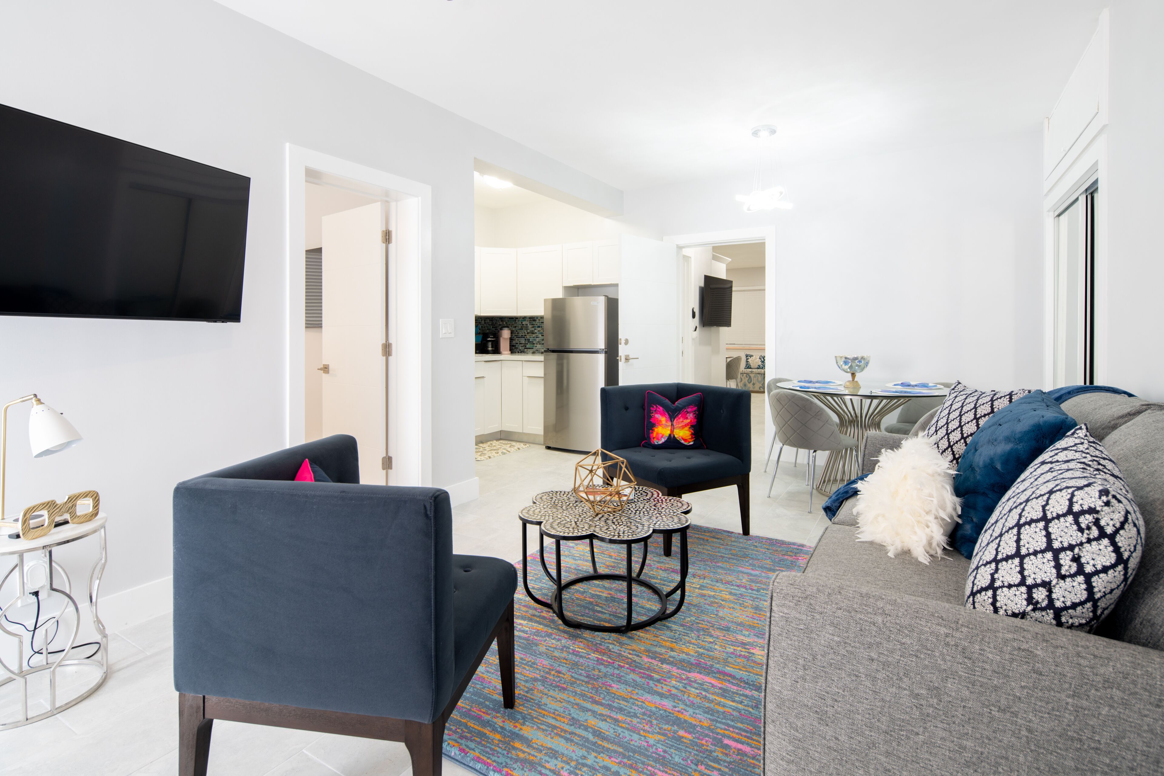 A modern living room with a grey sofa, a blue armchair, and a small round coffee table.
