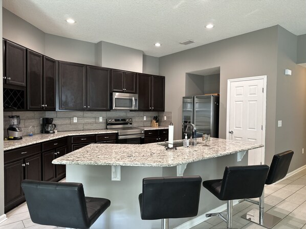 Enjoy cooking in this well-equipped kitchen with a granite countertop island, oven, and microwave.