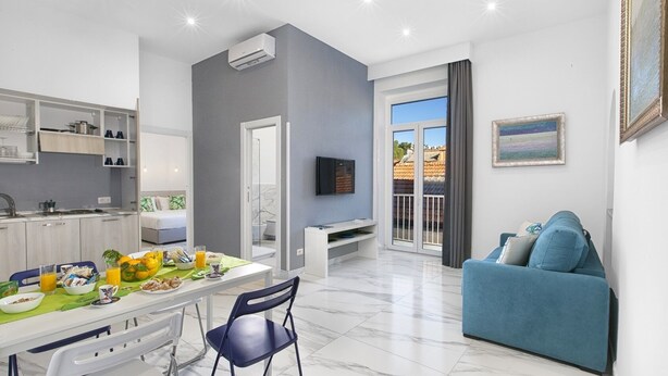 Un apartamento moderno con comedor, cocina, sala de estar y balcón.