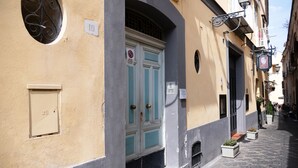 Una calle estrecha con edificios que tienen puertas abovedadas y números.