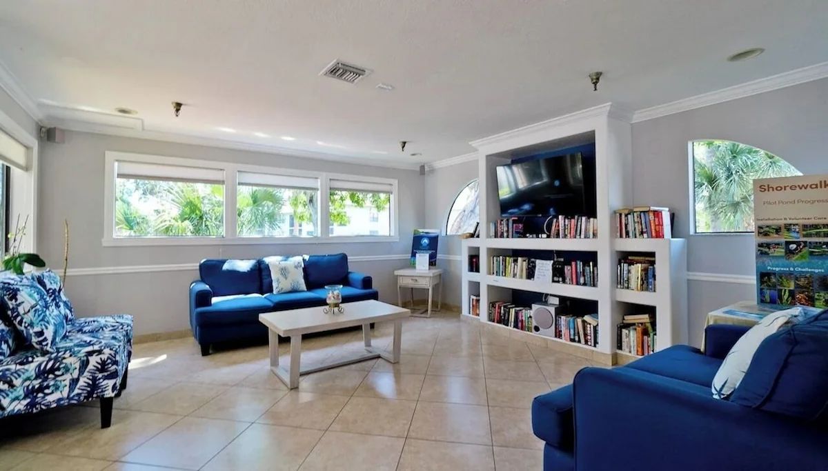 A living room with a blue sofa, a coffee table, and a bookshelf.