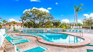 A pool area with lounge chairs and a circular pool. - *Casa Bella* Waterfront View! 2BR, w/2 Pools, Mins to IMG/Beach/Anna Maria Isl (Bradenton)