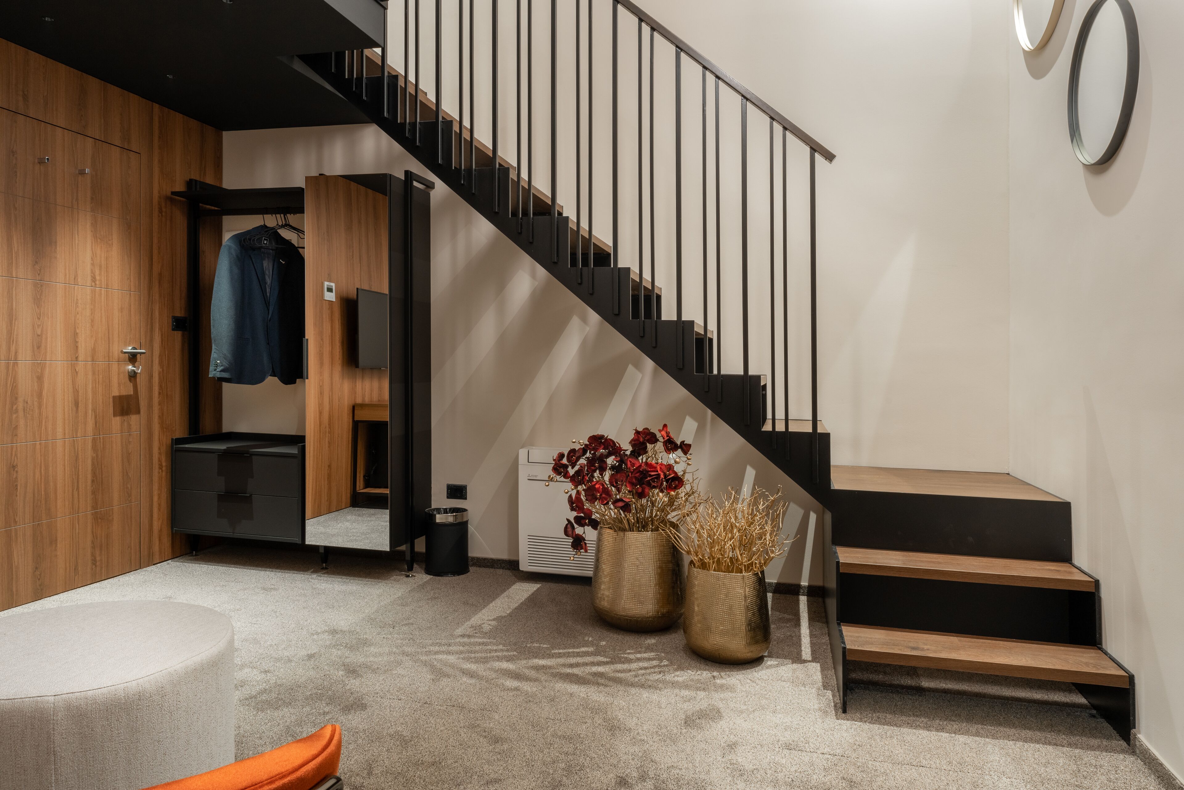 Eine moderne Treppe mit minimalistischem Design, eine Holzvertäfelung und eine Sitzgelegenheit mit einer Bank und einem kleinen Tisch.