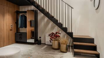 Eine moderne Treppe mit minimalistischem Design, eine Holzvertäfelung und eine Sitzgelegenheit mit einer Bank und einem kleinen Tisch.