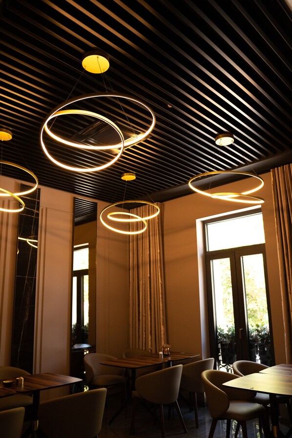 Un interior moderno con lámparas colgantes circulares, una mesa de madera y sillas.