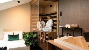 A modern hotel room with a bed, a massage table, and a sauna area. - DeGrassi Boutique Garni Hotel Izola (Izola)