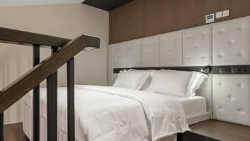 A modern bedroom with a wooden staircase, a tufted headboard, and a neutral color scheme.