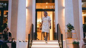 A man in a chef's uniform walking up a set of stairs to a building entrance. - DeGrassi Boutique Garni Hotel Izola (Izola)