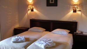 A double bed with white linens and two towels, two bedside tables with lamps, and a framed picture on the wall. - Hotel Rural Quinta de Novais (Arouca)