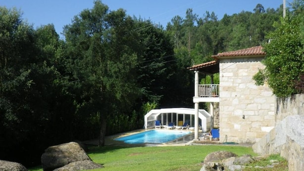 A stone building with a balcony and a swimming pool. - Hotel Rural Quinta de Novais (Arouca)