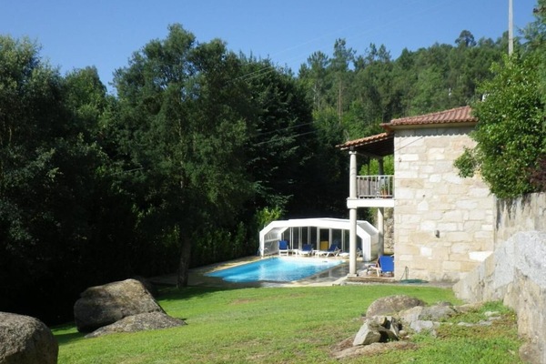 Een seizoensgebonden buitenzwembad en ligstoelen