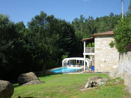 A stone building with a balcony and a swimming pool.