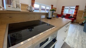 A modern kitchen with a built-in stove, oven, and a coffee maker. - "Little uncle" (Wiefelstede)
