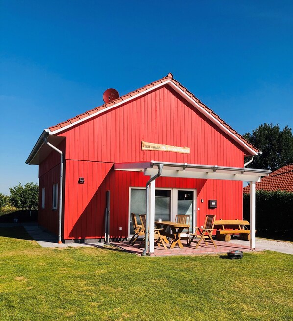 A red barn with a sign reading "Ferienhaus Kleiner Ortel".