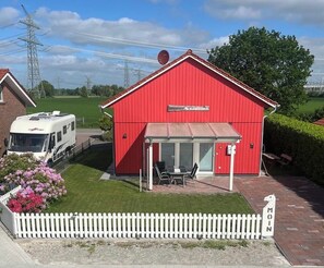 A red building with a sign 'Fennianhaus Kleiner Onkel' and a covered outdoor seating area.