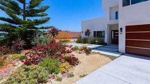 A modern two-story house with a well-maintained garden featuring various plants and flowers. - Oceanview Luxury Home - 5 Bedroom - 5 Baths - 3 Decks - Walk to Beach (San Diego)