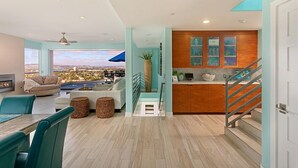 A modern living room with a fireplace, a dining area, and a view of the city. - Oceanview Luxury Home - 5 Bedroom - 5 Baths - 3 Decks - Walk to Beach (San Diego)