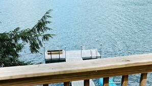 Une terrasse en bois offrant une vue sur un lac et un quai.