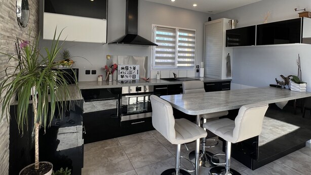 A modern kitchen with a central island, built-in appliances, and a large window. - FULLY AIR-CONDITIONED, COMFORTABLE HOUSE WITH PRIVATE POOL (Sauvian)