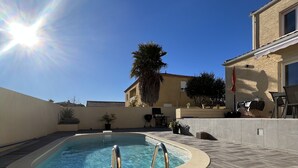 A swimming pool with metal railings, surrounded by a tiled deck and a building with a balcony. - FULLY AIR-CONDITIONED, COMFORTABLE HOUSE WITH PRIVATE POOL (Sauvian)