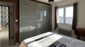 A bedroom with a bed, a wardrobe, a radiator, and a window. - FULLY AIR-CONDITIONED, COMFORTABLE HOUSE WITH PRIVATE POOL (Sauvian)