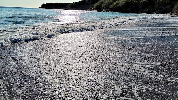 Een strand met een kiezelstrand en golven.