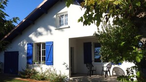 A white house with blue shutters, a covered porch, and a small garden. - Landes house 10 min from the beach, 5min from the cycle path and forest (Mimizan)
