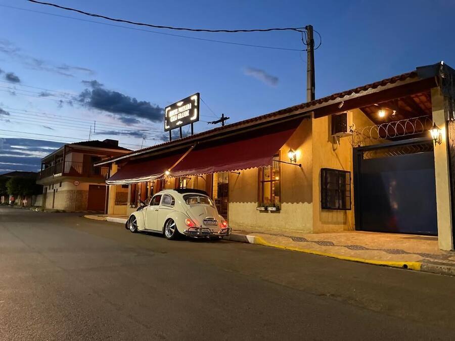 Un edificio con un letrero que dice "Hotel Pura de la Carretera" y un coche blanco estacionado al frente.
