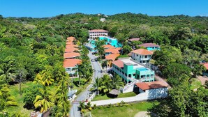 Un resort con varias edificaciones, una calle central y abundante vegetación.