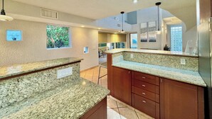 Una cocina con encimeras de granito, gabinetes de madera y horno empotrado.