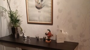 A kitchen with a dark countertop, a potted plant, a framed artwork, and a small figurine. - House Bergrose (Busenborn)