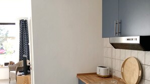 Una cocina moderna con armarios grises, encimera de madera, horno Bosch y tostadora.