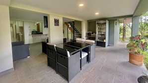Un amplio patio con mesa y sillas, un refrigerador y un microondas.