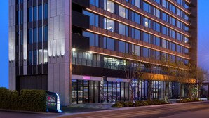 Un moderno edificio de hotel con un llamativo letrero 'HOTEL', varios pisos y una fachada bien iluminada.