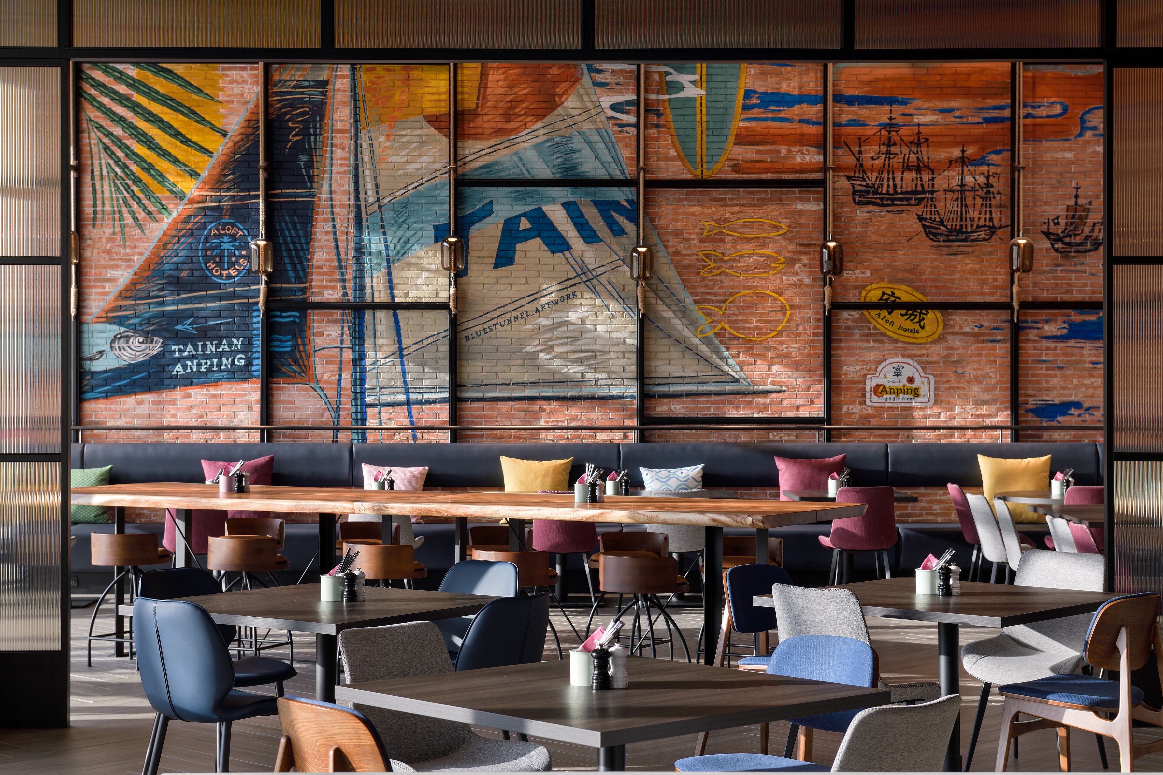 A restaurant with a long wooden table and multiple seating options, including booths and chairs.