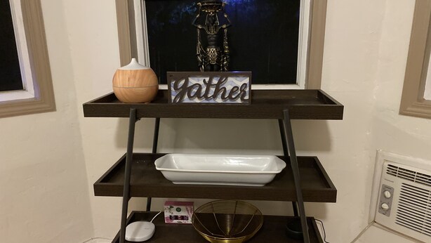 A wooden shelf with a sign reading "Father," a white plate, a white bowl, a white speaker, and a decorative item. - WHOLE Family - Barrette - Hostel (Sacramento)