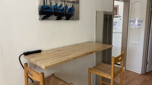 A room with a wooden table, two wicker chairs, a wall-mounted air conditioner, and a sign reading "Welcome to the Melow Room". - WHOLE Family - Barrette - Hostel (Sacramento)