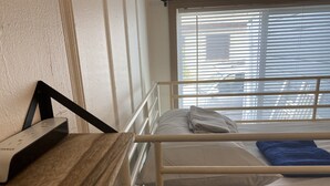 A bunk bed with a wooden desk and a window with blinds. - WHOLE Family - Barrette - Hostel (Sacramento)