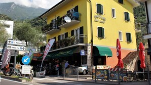 Un edificio amarillo con balcones, bar y terraza.